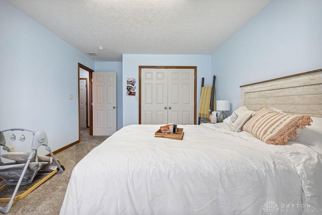 bedroom with carpet, a closet, baseboards, and a textured ceiling