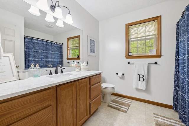 full bathroom featuring plenty of natural light, toilet, baseboards, and vanity