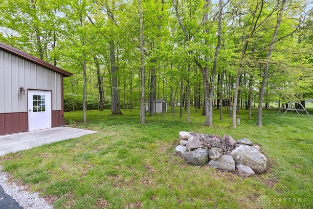 view of green lawn featuring an outbuilding and a storage unit