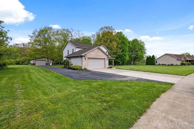 view of front of home featuring brick siding, a front yard, and driveway