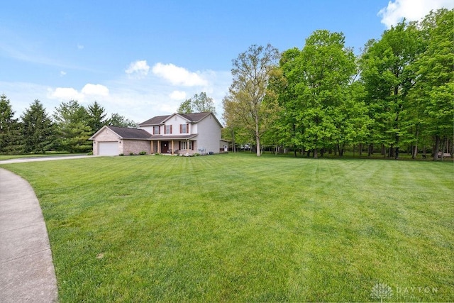view of grassy yard featuring driveway and an attached garage