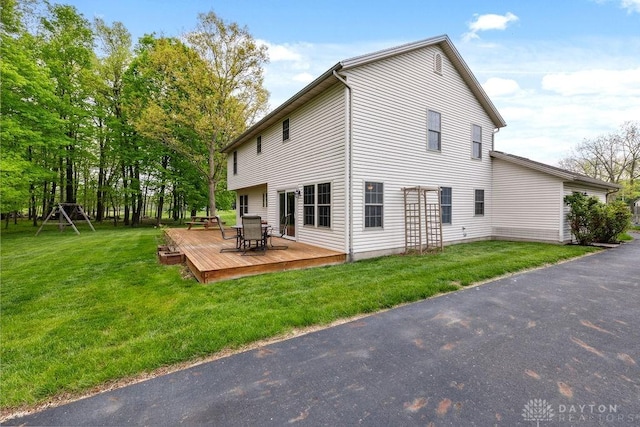 rear view of house featuring a deck and a yard