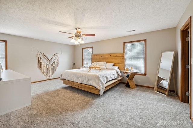 bedroom featuring carpet floors, baseboards, a textured ceiling, and ceiling fan