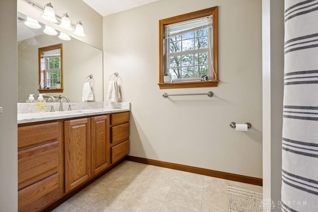 full bath featuring plenty of natural light, vanity, baseboards, and tile patterned floors