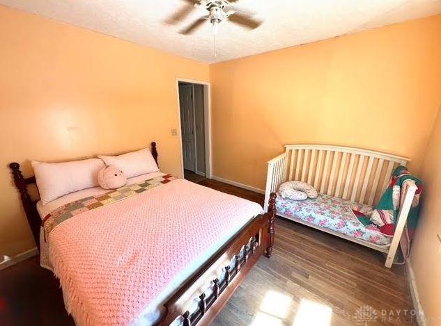 bedroom featuring wood finished floors, baseboards, and ceiling fan