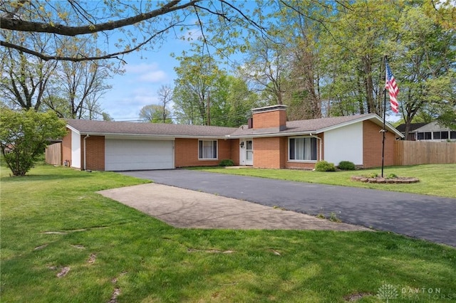ranch-style house featuring a garage, driveway, brick siding, and a chimney