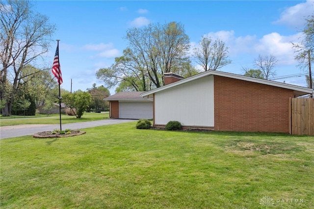 view of property exterior with a chimney, brick siding, and a detached garage