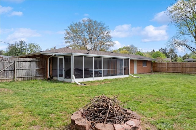 back of property with a sunroom and brick siding