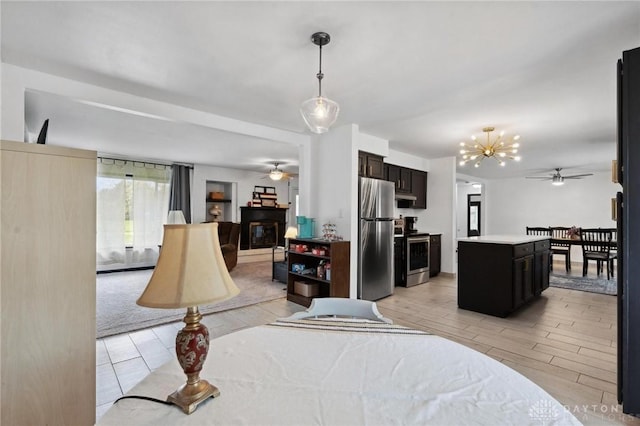 bedroom featuring freestanding refrigerator, a glass covered fireplace, light wood finished floors, and a chandelier