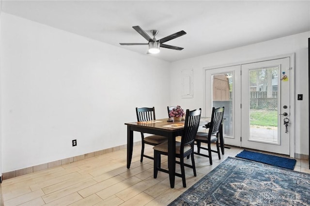 dining room featuring ceiling fan, baseboards, and light wood-style flooring