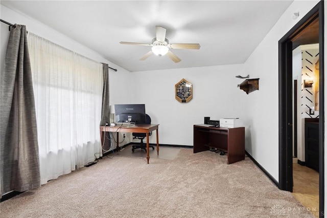 carpeted home office with a ceiling fan