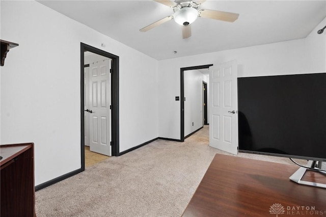 unfurnished bedroom with light carpet, baseboards, and ceiling fan