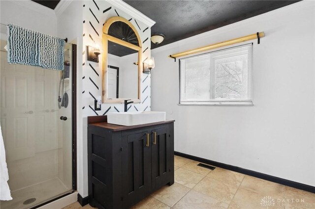 full bath with a shower stall, vanity, baseboards, crown molding, and tile patterned floors