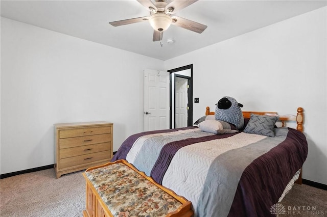 bedroom featuring light colored carpet, baseboards, and a ceiling fan