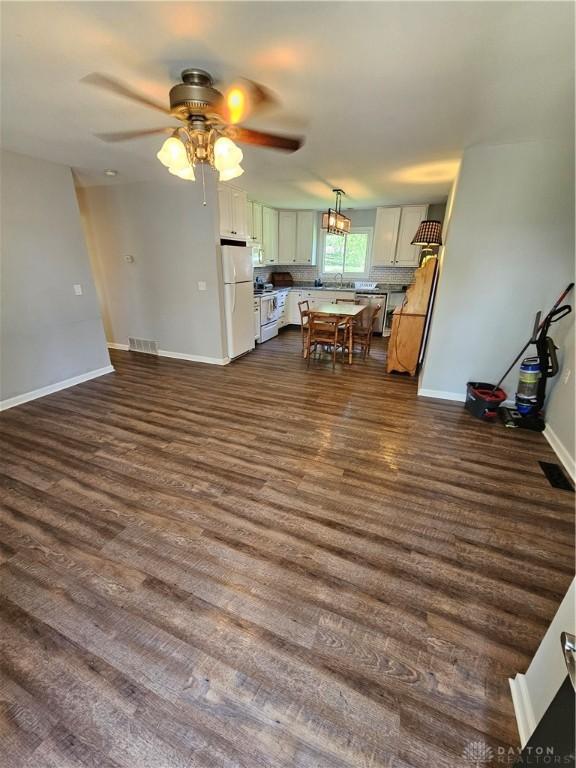 390 W Hendricks St, Camden, OH 45311 - unfurnished living room with ceiling fan, baseboards, dark wood-style floors, and a sink
