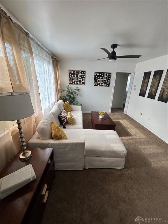 living room featuring carpet, a ceiling fan, and baseboards