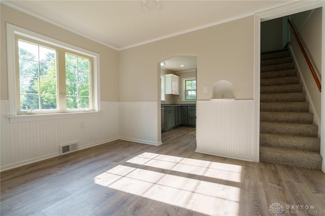 2182 La Grange Rd, Beavercreek, OH 45431 - spare room featuring light wood-style flooring, wainscoting, stairway, ornamental molding, and arched walkways