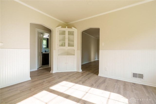 2182 La Grange Rd, Beavercreek, OH 45431 - empty room featuring arched walkways, light wood-type flooring, wainscoting, and crown molding