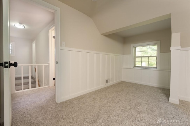 2182 La Grange Rd, Beavercreek, OH 45431 - carpeted empty room featuring a wainscoted wall, vaulted ceiling, and a decorative wall