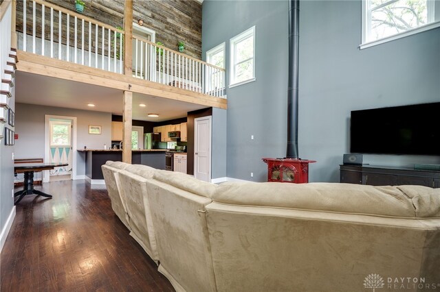1803 Resor Rd, Fairfield, OH 45014 - living area featuring a towering ceiling, a wood stove, dark wood-style flooring, and baseboards