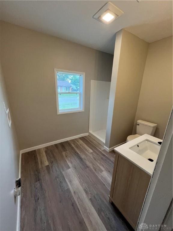 clothes washing area featuring dark wood-type flooring, a sink, and baseboards