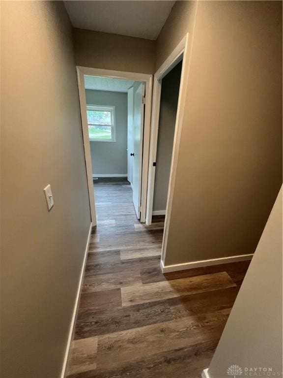 hallway with baseboards and dark wood-style floors