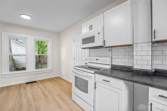 1235 W Jefferson St, Springfield, OH 45506 - kitchen featuring white appliances, baseboards, dark countertops, light wood-style flooring, and tasteful backsplash