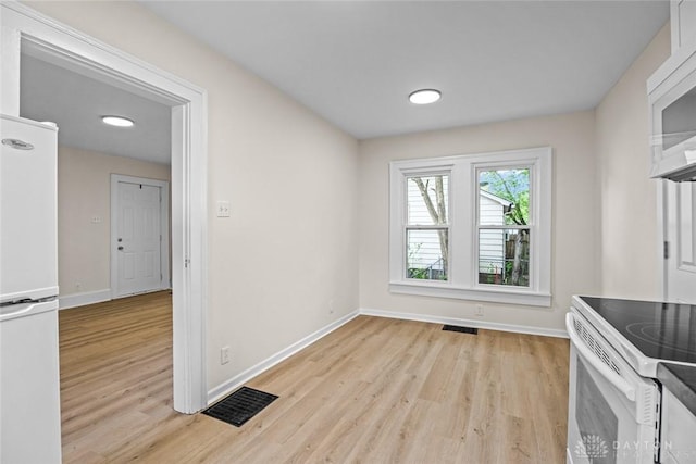 1235 W Jefferson St, Springfield, OH 45506 - unfurnished dining area with light wood-type flooring and baseboards
