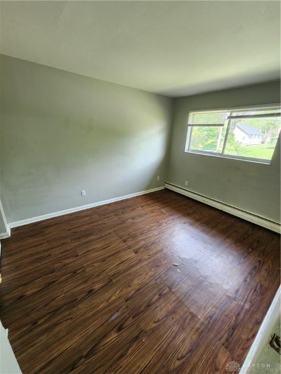 2620 N Gettysburg Ave, Dayton, OH 45406 - unfurnished room with a baseboard radiator, dark wood-style floors, and baseboards