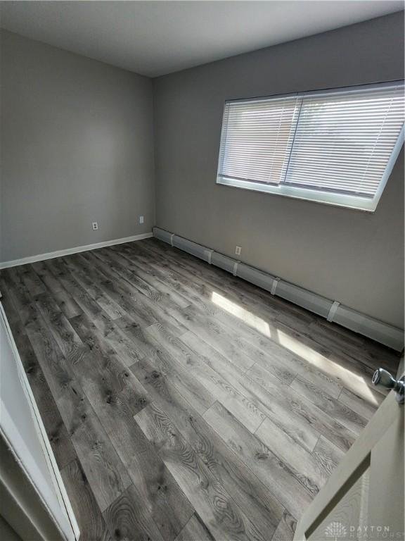 2620 N Gettysburg Ave, Dayton, OH 45406 - spare room featuring wood finished floors, baseboard heating, and baseboards
