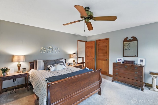 carpeted bedroom featuring baseboards, a closet, and a ceiling fan