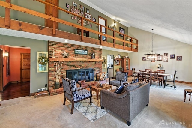 living area featuring carpet, a fireplace, baseboards, a chandelier, and high vaulted ceiling