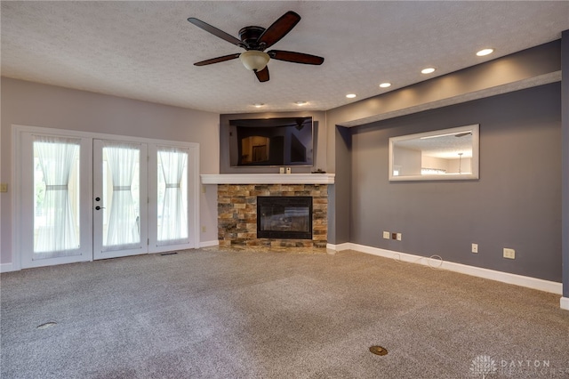 unfurnished living room with carpet, a ceiling fan, french doors, a textured ceiling, and baseboards