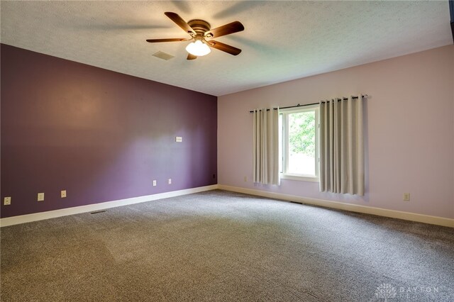 spare room featuring ceiling fan, carpet flooring, baseboards, and a textured ceiling