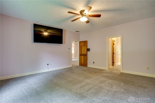 carpeted spare room with ceiling fan, baseboards, and a textured ceiling