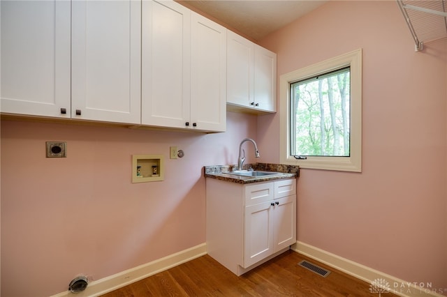 laundry area with electric dryer hookup, cabinet space, washer hookup, wood finished floors, and baseboards