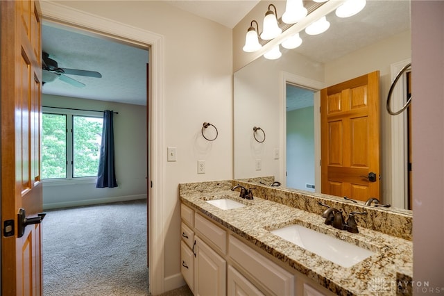 bathroom featuring double vanity, baseboards, a chandelier, and a ceiling fan