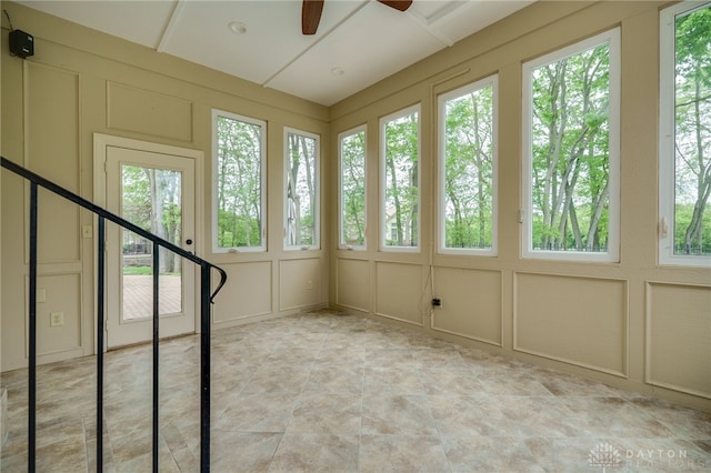 unfurnished sunroom featuring plenty of natural light and a decorative wall