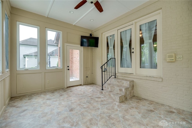 unfurnished sunroom with brick wall and a decorative wall