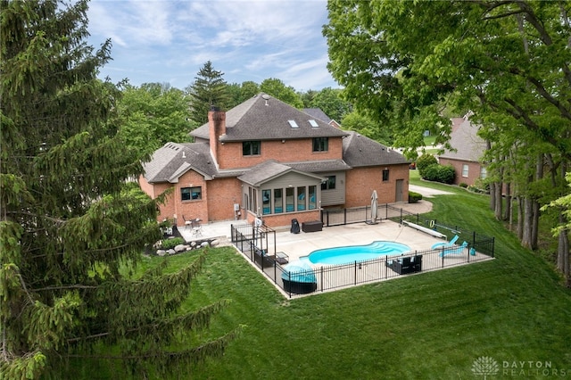 rear view of property with brick siding, a patio area, a chimney, and roof with shingles