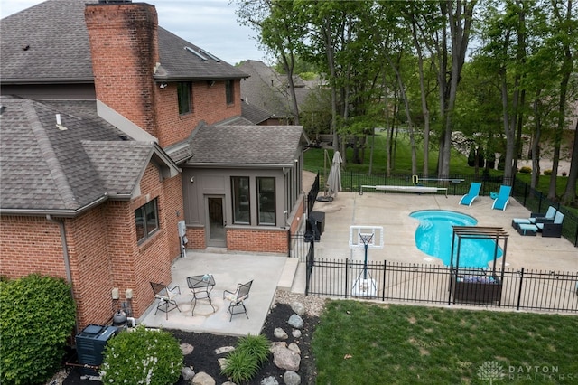 community pool featuring a fenced backyard, a patio area, and central AC unit