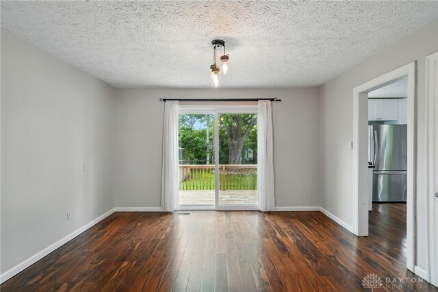 2917 California Ave, Dayton, OH 45419 - spare room featuring dark wood-type flooring, baseboards, and a textured ceiling