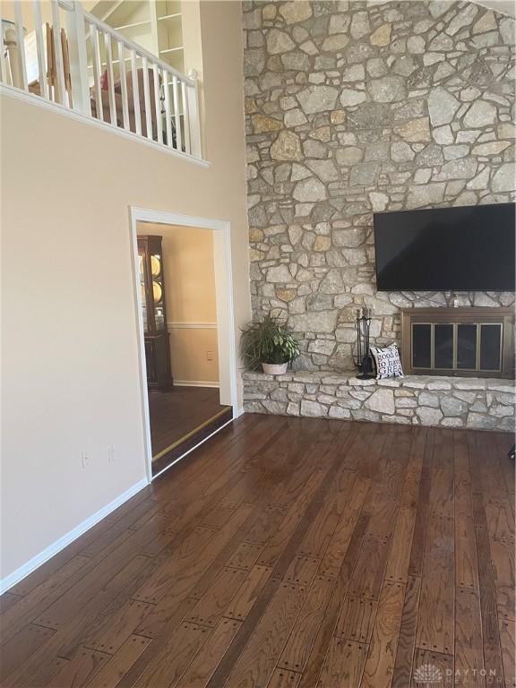 3033 E Linmuth Dr, Springfield, OH 45503 - unfurnished living room with hardwood / wood-style flooring, baseboards, and a glass covered fireplace