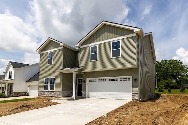 3402 Randall Dr, Cedarville Twp, OH 45314 - view of front facade featuring stone siding, concrete driveway, and a garage
