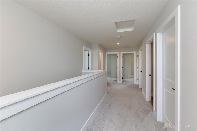 3402 Randall Dr, Cedarville Twp, OH 45314 - hallway featuring light carpet, a textured ceiling, and attic access