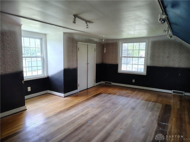 465 W Staunton Rd, Troy, OH 45373 - unfurnished bedroom with track lighting, hardwood / wood-style flooring, multiple windows, and vaulted ceiling