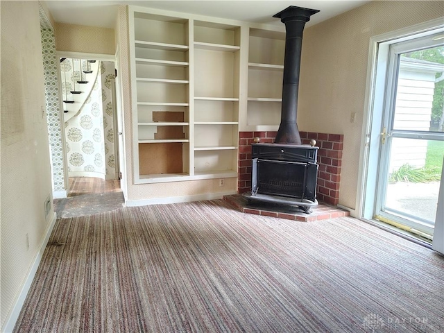 465 W Staunton Rd, Troy, OH 45373 - unfurnished living room featuring carpet floors, baseboards, and a wood stove