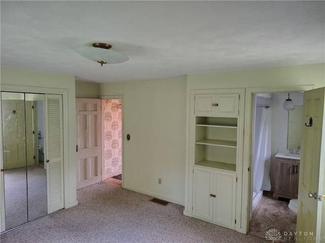 465 W Staunton Rd, Troy, OH 45373 - unfurnished bedroom featuring carpet flooring, baseboards, a sink, and ensuite bath