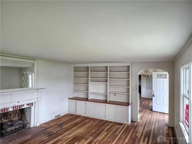 465 W Staunton Rd, Troy, OH 45373 - unfurnished living room featuring arched walkways, dark wood-style floors, a fireplace, baseboards, and ornamental molding