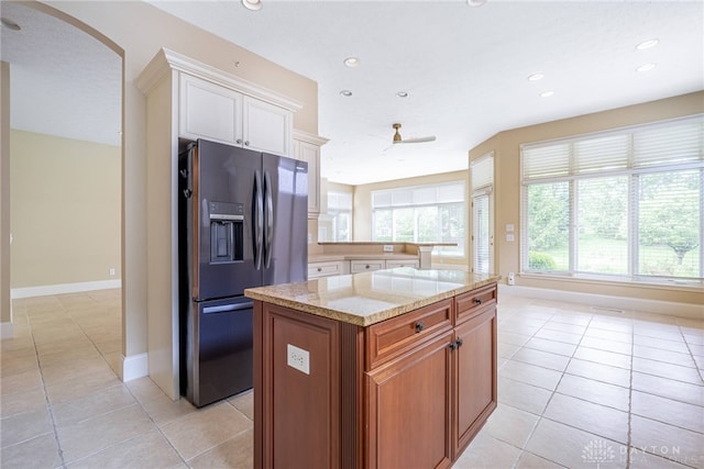 1154 Club View Dr, Centerville, OH 45458 - kitchen featuring refrigerator with ice dispenser, light tile patterned flooring, arched walkways, light stone counters, and recessed lighting